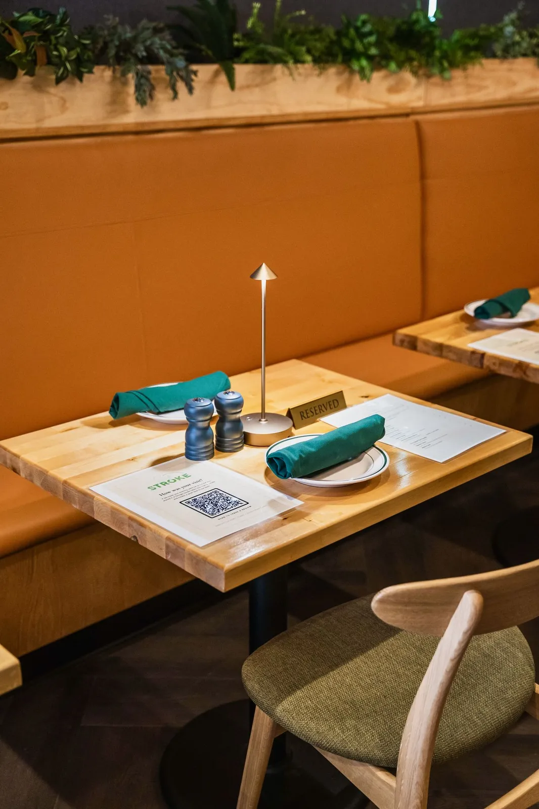 Green banquette seating along the wall of the dining room